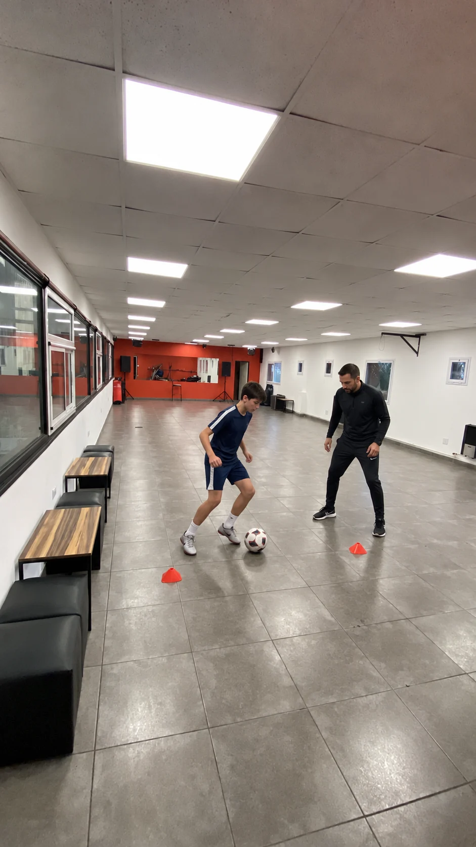 Escena ilustrativa de entrenamiento personalizado de fútbol sobre una foto real del complejo
